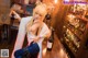 A woman sitting at a bar holding a glass of wine.