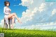 A woman sitting on a chair in a grassy field.