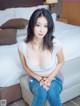 A woman sitting on top of a bed in a bedroom.