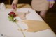 A woman is putting a rose on a massage table.