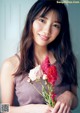 A woman holding a bunch of flowers in her hands.