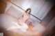 A naked woman sitting on a couch holding a clapper board.