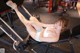 A woman is sitting on a bench in a gym.