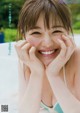 A woman in a blue bikini smiling at the camera.